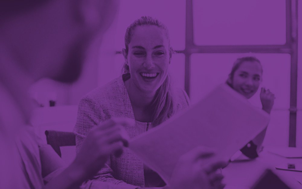 Colleagues at a meeting sharing information. The picture has a transparent purple.